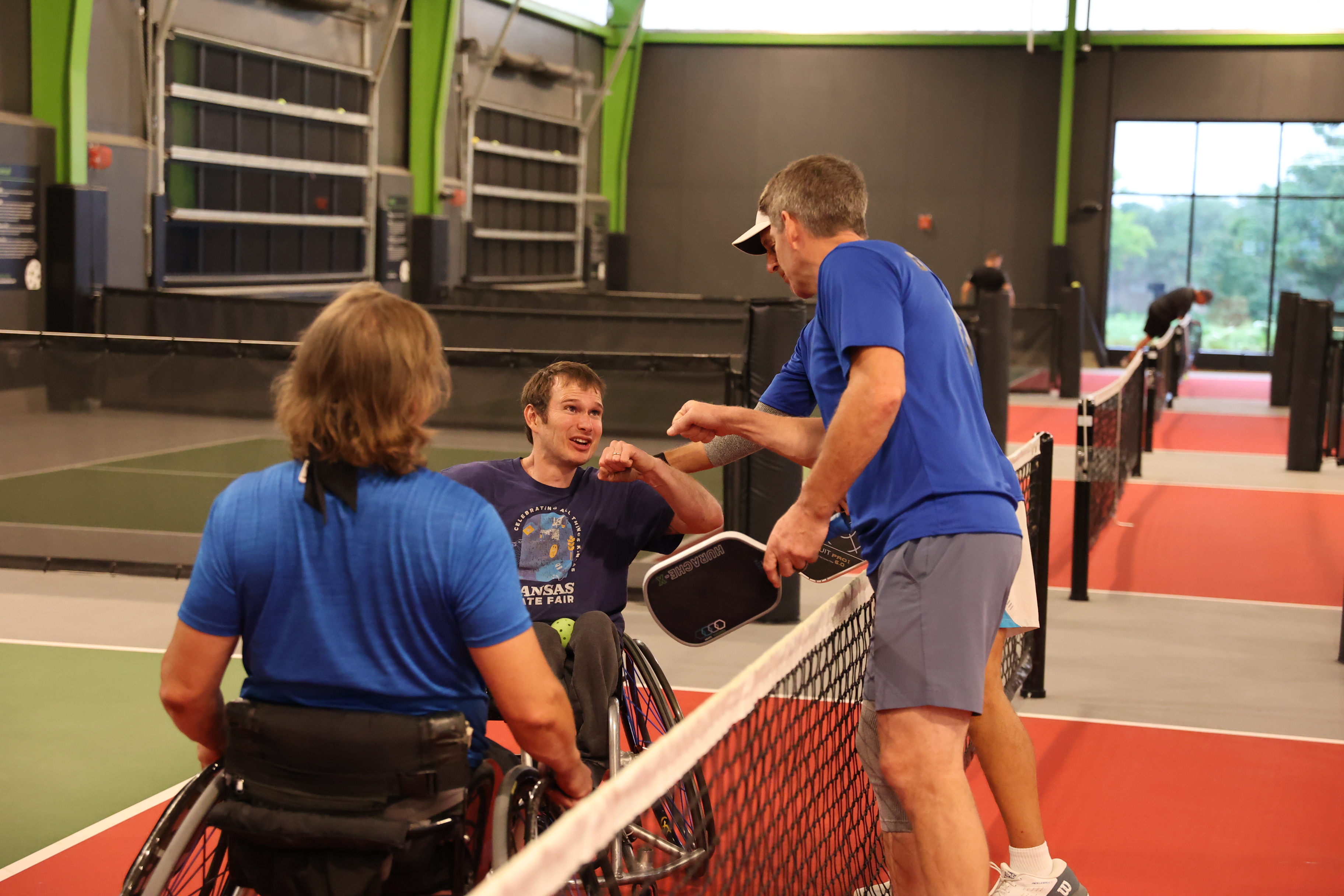 Team members fist bumping at the net 